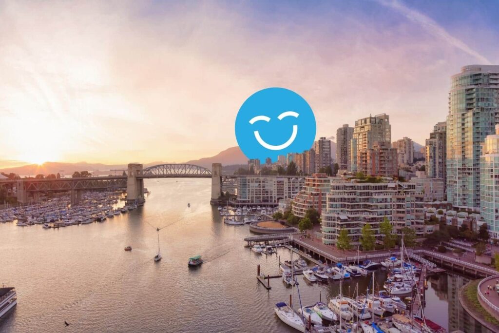 Sunset view of a city harbor with boats and skyscrapers, featuring a bridge in the background and a large smiling face icon in the sky.